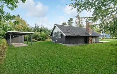 a small black house with a grass yard at Holiday Home Agathesvej Løgstør V in Løgstør