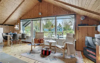 a living room with a table and chairs and a large window at Holiday Home Agathesvej Løgstør V in Løgstør