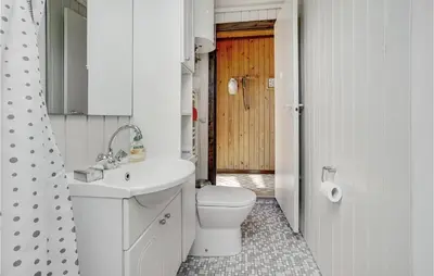 a white bathroom with a toilet and a sink at Holiday Home Agathesvej Løgstør V in Løgstør
