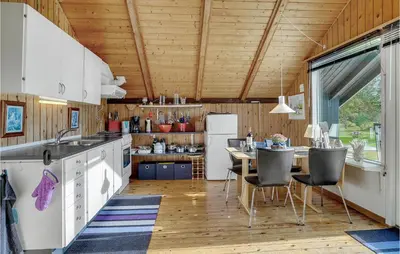 a kitchen with a table and a dining room at Holiday Home Agathesvej Løgstør V in Løgstør