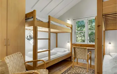 a bedroom with bunk beds with a table and chairs at Holiday Home Furvej in Vesløs
