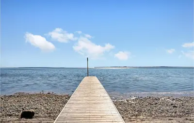 a wooden pier with a light pole on a body of water at Holiday Home Furvej in Vesløs