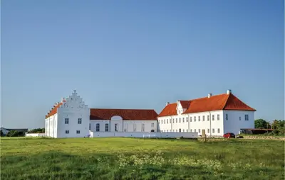 a large white building with a red roof on a field at Holiday Home Hellesvej Løgstør Xi in Løgstør