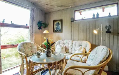 a living room with a couch and a table and chairs at Holiday Home Hellesvej Løgstør Xi in Løgstør