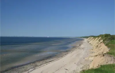 a sandy beach with the ocean in the background at Holiday Home Bjarkesvej in Farsø