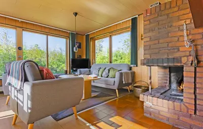 a living room with a brick wall and a fireplace at Holiday Home Bjarkesvej in Farsø