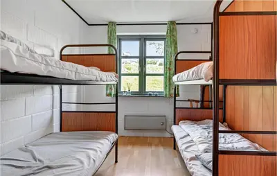 a dorm room with three bunk beds and a window at Holiday Home Eskovvej in Roslev