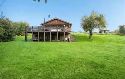 a house on a green field with a tree at Holiday Home Eskovvej in Roslev