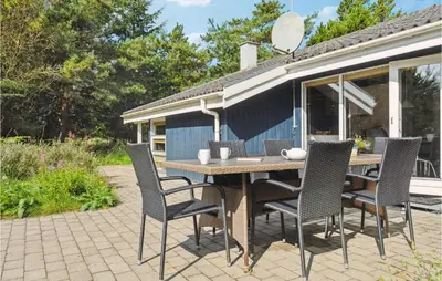 a table and chairs on a patio in front of a caravan at Holiday Home Revlingestien Fjerritslev V in Fjerritslev
