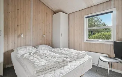 a bedroom with a bed and a window and a chair at Holiday Home Revlingestien Fjerritslev V in Fjerritslev