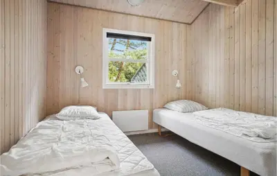 two beds in a room with a window at Holiday Home Revlingestien Fjerritslev V in Fjerritslev