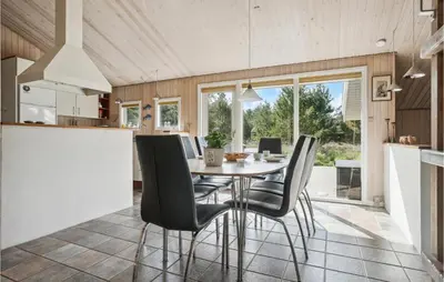 a kitchen and dining room with a table and chairs at Holiday Home Revlingestien Fjerritslev V in Fjerritslev