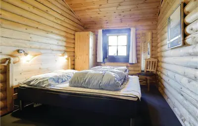 a bedroom with a bed in a wooden cabin at Holiday Home Lyngbjergvej Vi in Fjerritslev