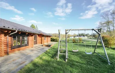 a yard with a log cabin with a swing at Holiday Home Lyngbjergvej Vi in Fjerritslev