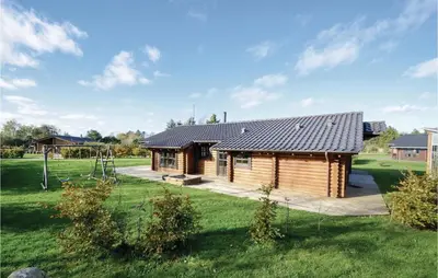 a log cabin in a field with a yard at Holiday Home Lyngbjergvej Vi in Fjerritslev