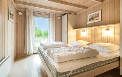 a bedroom with two beds and a window at Holiday Home Revlingestien Fjerritslev Iv in Fjerritslev