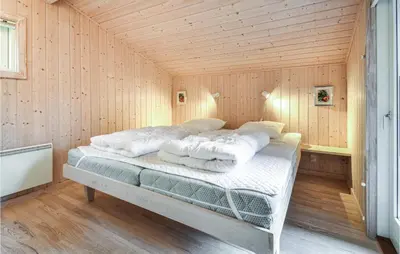 a bedroom with a bed in a wooden room at Holiday Home Revlingestien Fjerritslev Iv in Fjerritslev