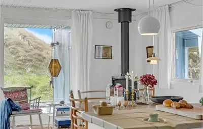 a kitchen with a table and a large window at Holiday Home Svenstibakkevej Denm in Frøstrup