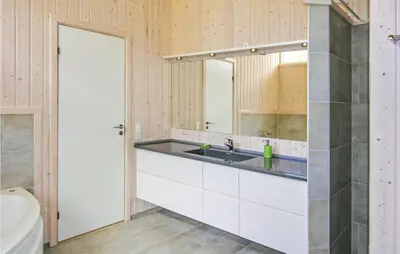 a bathroom with a sink and a mirror at Holiday Home Revlingestien Fjerritslev Denm in Fjerritslev