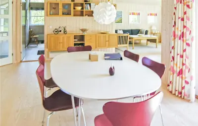 a dining room with a white table and chairs at Holiday Home Revlingestien Fjerritslev Denm in Fjerritslev