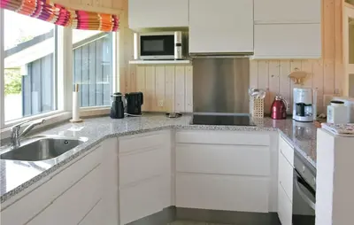 a kitchen with white cabinets and a sink at Holiday Home Revlingestien Fjerritslev Denm in Fjerritslev
