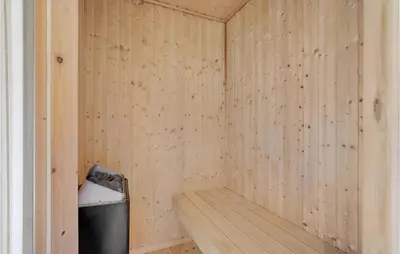a small wooden sauna with a trash can in it at Holiday Home Rønnevej Fjerritslev Ix in Fjerritslev