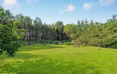 a large field with a playground in a park at Holiday Home Rønnevej Fjerritslev Ix in Fjerritslev