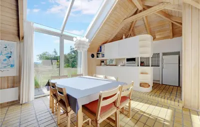 a kitchen and dining room with a table and chairs at Holiday Home Tulipanvej Fjerritslev I in Fjerritslev