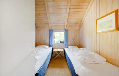 two beds in a small room with a window at Holiday Home Tulipanvej Fjerritslev I in Fjerritslev
