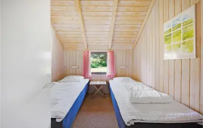 two beds in a small room with a window at Holiday Home Tulipanvej Fjerritslev I in Fjerritslev