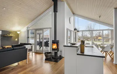 a kitchen and living room with a fireplace in a house at Holiday Home Kronvildtvej Brovst Vi in Brovst