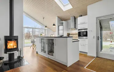 a kitchen with a fireplace and a stove at Holiday Home Kronvildtvej Brovst Vi in Brovst