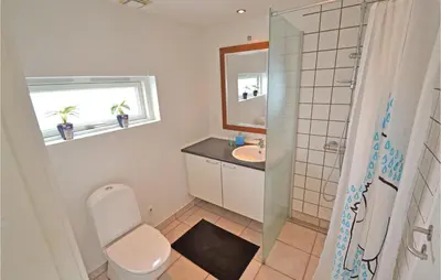 a bathroom with a toilet and a sink and a shower at Holiday Home Kronvildtvej Brovst X in Brovst
