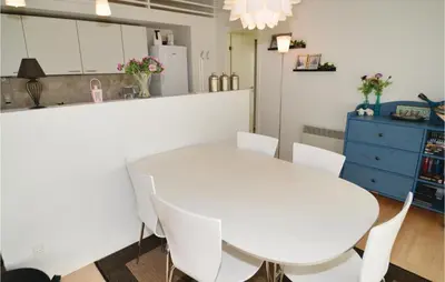 a white kitchen with a white table and chairs at Holiday Home Kronvildtvej Brovst X in Brovst