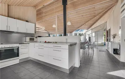 a kitchen with white cabinets and a wooden ceiling at 4 Bedroom Gorgeous Home In Fjerritslev in Fjerritslev