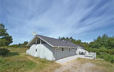 a white barn with a bench in a field at 4 Bedroom Gorgeous Home In Fjerritslev in Fjerritslev