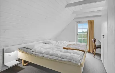 a white bedroom with a bed and a window at Pee Klims Hus in Brovst