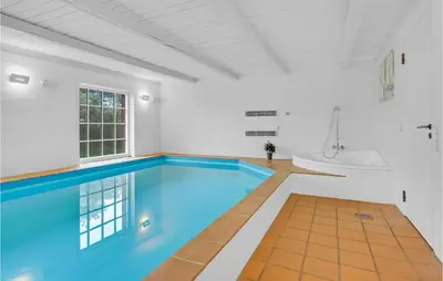 an indoor swimming pool with a tub and a sink at Pee Klims Hus in Brovst