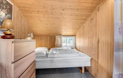 a bedroom with a bed in a wooden room at Holiday Home Svenstibakkevej Denmark Ii in Frøstrup