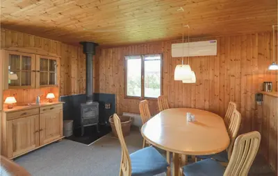 a dining room with a table and a stove at Holiday Home Svenstibakkevej Frøstrup Iv in Frøstrup