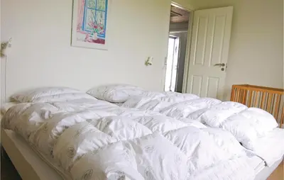 a group of white pillows sitting on top of a bed at Gorgeous Home In Frøstrup With Wifi in Frøstrup