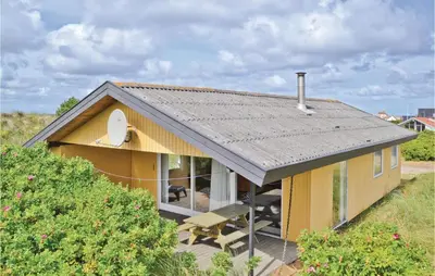 a small yellow house with a large window at Holiday Home Svenstibakkevej Frøstrup Xii in Frøstrup