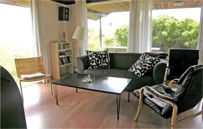 a living room with a green couch and a table at Holiday Home Svenstibakkevej Frøstrup Xii in Frøstrup
