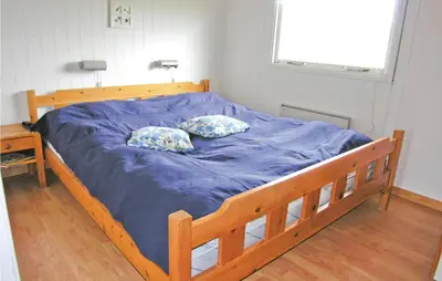 a bed with blue sheets and two pillows on it at Holiday Home Svenstibakkevej Frøstrup Xii in Frøstrup