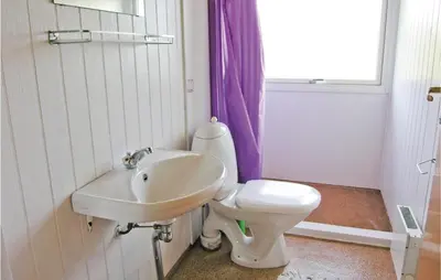a bathroom with a white toilet and a sink at Holiday Home Svenstibakkevej Frøstrup Xii in Frøstrup