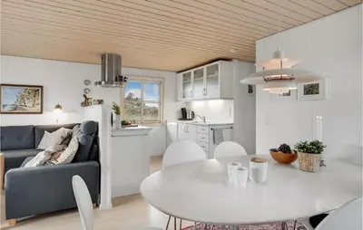 a kitchen and a living room with a table and a couch at Holiday Home Svenstibakkevej Denmark in Frøstrup