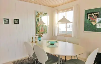 a dining room with a white table and chairs at Holiday Home Svenstibakkevej Denmark in Frøstrup
