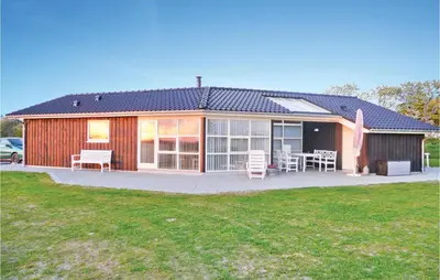 a house with a patio and a table and chairs at Holiday Home Aspevej Fjerritslev Xi in Fjerritslev