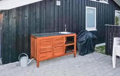 a wooden cabinet with a sink on a patio at Holiday Home Aspevej Fjerritslev Xi in Fjerritslev