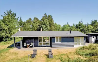 a house with a picnic table and chairs in the yard at Jydehuset in Fjerritslev